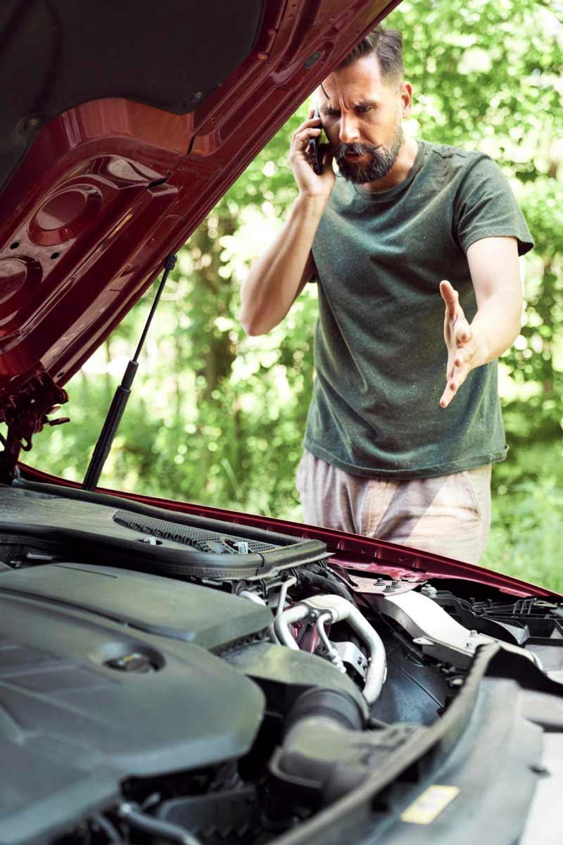 Junger Mann prüft Getriebeschaden bei Schrottauto Ankauf Oberhausen